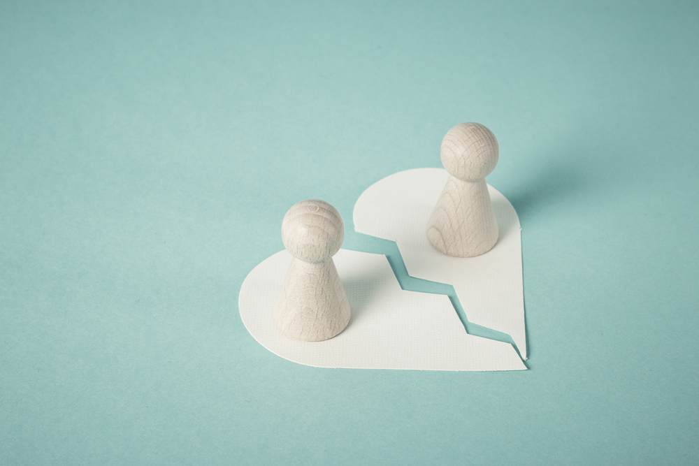 Zwei Figuren auf einem gebrochenen Herzen. 